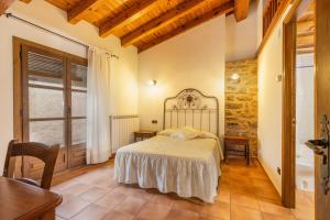 a bedroom with a bed and a table and a window at Casa Vilanova in Peramea