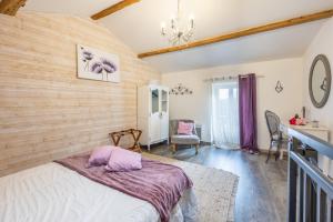 a bedroom with a bed and a chandelier at Le Clemenceau in Les Épesses