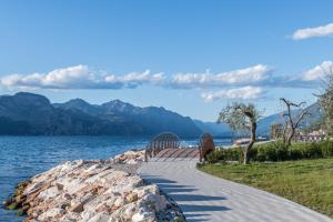a walkway next to a body of water at Lola Home Brenzone in Brenzone sul Garda
