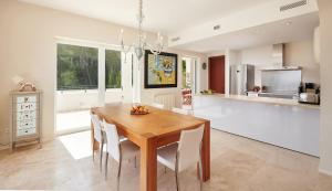 a kitchen and dining room with a wooden table and chairs at Can Pascalou in Canyamel