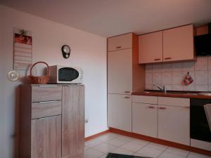 a kitchen with white cabinets and a microwave at Börsighof in Seebach