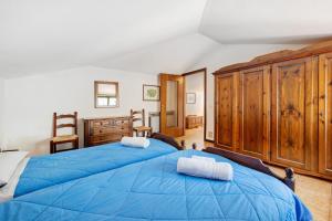 a bedroom with a large blue bed with wooden cabinets at Appartamento Rupestre 2.0 in Manerba del Garda