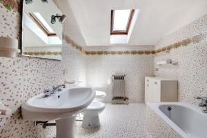 a bathroom with a sink and a toilet and a tub at Appartamento Rupestre 2.0 in Manerba del Garda +19 photos