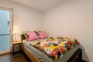 a bedroom with a bed with a colorful comforter at Wohnung 4 Rosenstraße in Cham