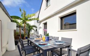 a dining table and chairs on a patio at Ty Laouen Gite Quiberon in Quiberon