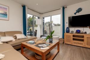 a living room with a couch and a tv at Ty Laouen Gite Quiberon in Quiberon