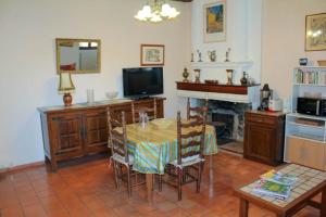 a living room with a table and a tv and a fireplace at Gîte Clarisse, piscine, animaux, pk in Allemagne-en-Provence