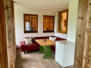 a living room with a table and a red couch at Haus Auner Top 1 in Westendorf
