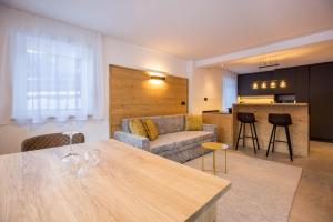 a living room and kitchen with a couch and a table at Apartments Armeri Black Dolomites in San Vigilio Di Marebbe +17 photos