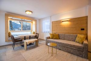 a living room with a couch and a table at Apartments Armeri Black Dolomites in San Vigilio Di Marebbe