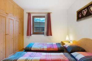 a bedroom with two beds and a window at Sprenghof Ferienwohnung in Sarntal