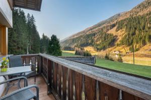 a balcony with a table and chairs and mountains at Sprenghof Ferienwohnung in Sarntal