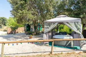 a gazebo with a hot tub in a yard at Cocoon insolite in Pernes-les-Fontaines