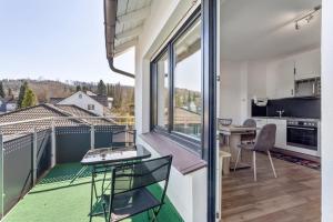 a balcony with a table and chairs and a kitchen at Ferienwohnung am Kurpark Brilon in Brilon