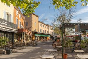 an empty street with tables and chairs and buildings at Cocoon insolite in Pernes-les-Fontaines
