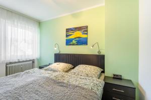 a bedroom with green walls and a bed with two lamps at Ferienwohnung am Kurpark Brilon in Brilon