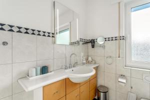 a bathroom with a sink and a mirror at Ferienwohnung am Kurpark Brilon in Brilon +28 photos