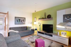 a living room with a couch and a flat screen tv at Huus Meernmank in Achtrup