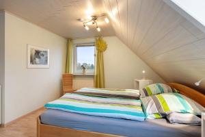 a bedroom with two beds and a window at Huus Meernmank in Achtrup