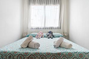 Drei Stofftiere sitzen auf einem Bett in einem Schlafzimmer in der Unterkunft Vendrell Centre in El Vendrell