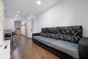 ein Wohnzimmer mit Sofa und eine Küche in der Unterkunft Vendrell Centre in El Vendrell
