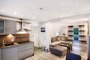 a kitchen and living room with a couch and a table at Lausebuche Im Sauerland in Lennestadt