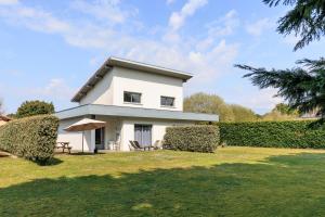 a white house with a lawn in front of it at Maison La Dune, Piscine et Jardin in Messanges