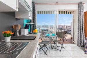 a kitchen with a table and chairs and a balcony at Bella mar in L'Escala +12 photos
