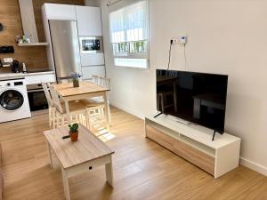 a living room with a tv and a table and a kitchen at La Coqueta in Zarandona