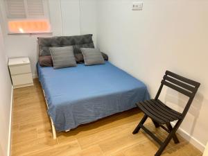 a small bedroom with a bed and a chair at La Coqueta in Zarandona +2 photos