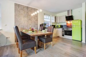 a kitchen with a wooden table and a green refrigerator at Haus Segelboot Hirtenweg 3c in Zingst