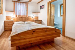 a bedroom with a wooden bed and wooden floors at Lindenhof Apt 8 in Vandoies