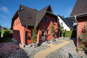 a house with a cobblestone walkway in front of it at Haus Segelboot Hirtenweg 3c in Zingst