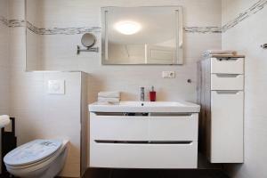 a bathroom with a white sink and a toilet at Haus Segelboot Hirtenweg 3c in Zingst +25 photos
