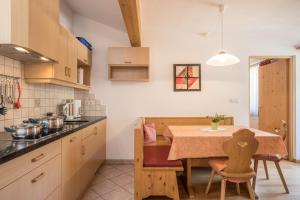 a kitchen with a table and a dining room at Apartment Kornblume - Mesnerhof in Sand in Taufers