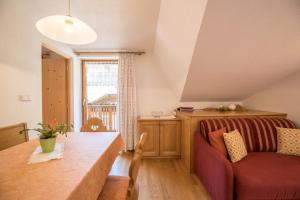 a living room with a couch and a table at Apartment Kornblume - Mesnerhof in Sand in Taufers