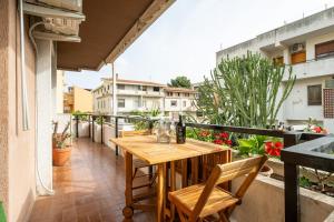 a balcony with a wooden table and chairs at Sa Mariposa in Cagliari