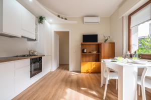 a kitchen with white cabinets and a white table at Sa Mariposa in Cagliari +15 photos