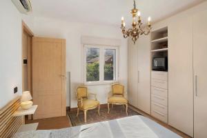 a bedroom with two chairs and a chandelier at Santa Lucia in Imperia