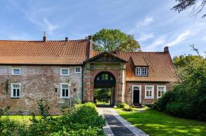 an old brick house with a large door at Perle von Berumbur in Berumbur