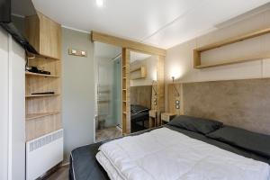 a bedroom with a bed and a room with a desk at Mobile Home du Bois Dormant in Saint-Jean-de-Monts +70 photos