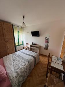 a bedroom with a bed and a table and a window at Chambres D'hôtes Mongarny Cancale in Cancale