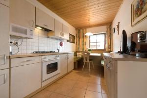 a kitchen with white appliances and a table in it at Apartment Dolomitenblick in Mühlbach