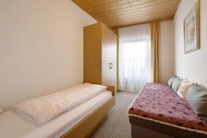 a small bedroom with a bed and a window at Apartment Dolomitenblick in Mühlbach +8 photos