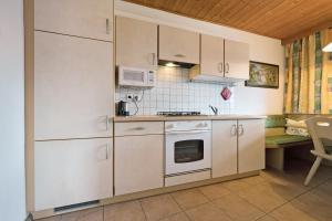 a kitchen with white cabinets and a stove at Apartment Dolomitenblick in Mühlbach