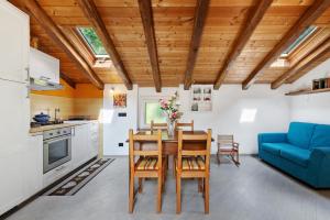 a kitchen with a dining room table and a blue couch at Maison Nature e Relax Zaffiro in Osiglia
