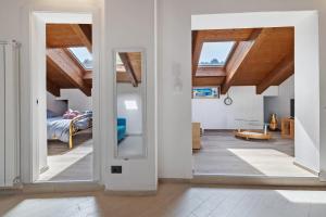 a room with white walls and wooden ceilings and a bedroom at Maison Nature e Relax Zaffiro in Osiglia