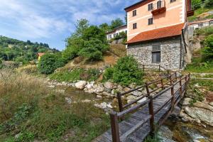 a building on a hill next to a river at Maison Nature e Relax Zaffiro in Osiglia