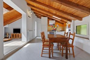 a dining room with a wooden table and chairs at Maison Nature e Relax Zaffiro in Osiglia