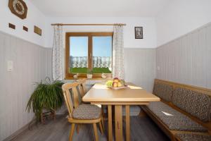 a dining room with a table and chairs and a window at Landhaus Moos in Argenbühl